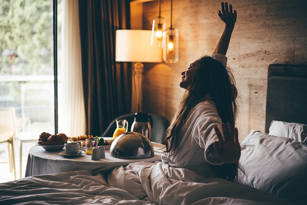Vrouw wordt wakker met een lekker ontbijtje op haar hotelkamer in het Hart van Limburg