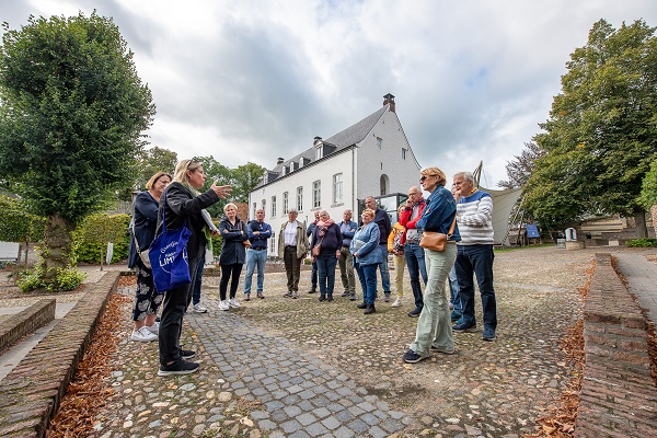 Groep luistert naar de gids die vertelt over de geschiedenis van Thorn