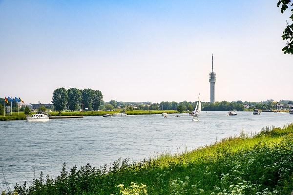 Verschillende boten varen op de Maas bij het dorpje Herten nabij Roermond